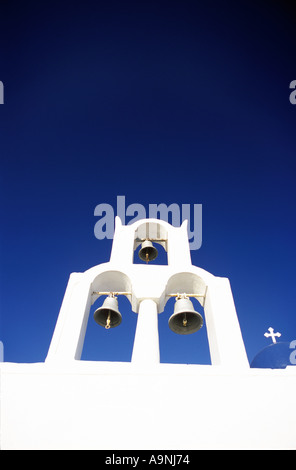 Griechisch-orthodoxe Kirchenglocken in Santorini gegen blauen Himmel mit kleinen Kreuz Stockfoto