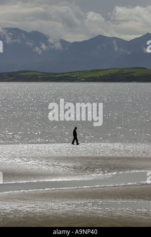 Einsamer Mann zu Fuß am Strand Stockfoto
