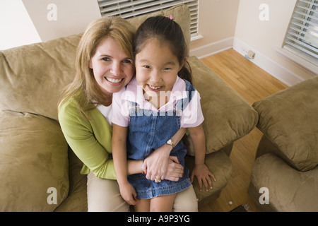 Porträt einer Mutter mit ihrer Tochter auf sofa Stockfoto