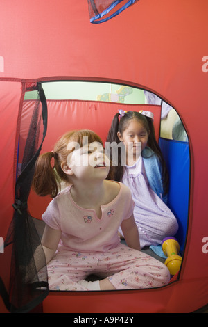 Kinder sitzen im Zelt Stockfoto