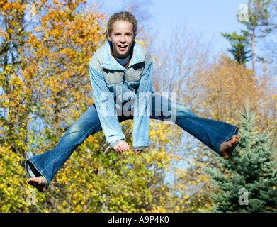 Mädchen in der Luft mit Herbstlaub springen Stockfoto