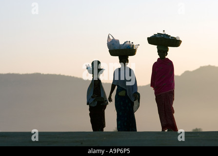 Silhouette der indischen Frauen waren in Körben auf ihren Köpfen tragen. Andhra Pradesh, Indien Stockfoto