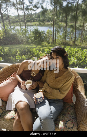Mutter und Tochter sitzen nebeneinander auf einem Stuhl Stockfoto