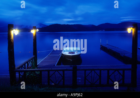 USA New York Lake Placid Motorboot am Pier vor Anker in der Nacht mit Blautönen Stockfoto