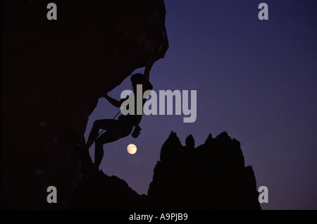 Eine Frau Klettern vor den Mond bei Smith Rock OR Stockfoto