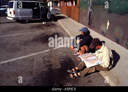 Zwei Männer auf der Suche an einer Straße Karte sitzen vor einem Restaurant in Lone Pine CA Stockfoto