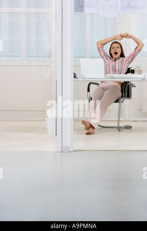 Büroangestellter Gähnen und dehnen Stockfoto