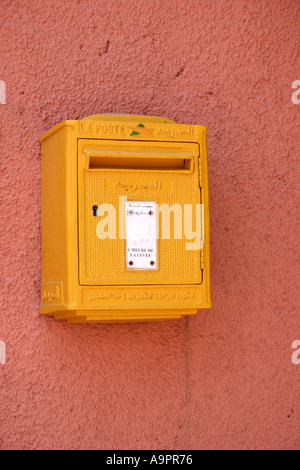 Gelber Briefkasten auf Rosa Wand Stockfoto