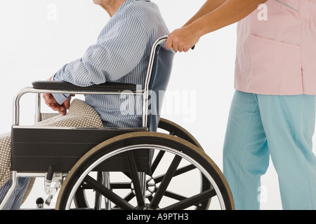 Krankenschwester drängen Mann im Rollstuhl Stockfoto