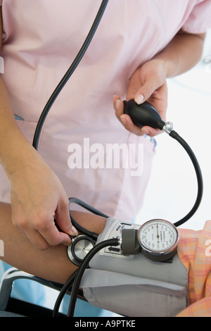 Krankenschwester, die die Patienten Blutdruckmessung Stockfoto