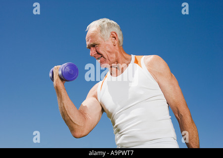 Älteren Erwachsenen Mannes eine Hantel heben Stockfoto