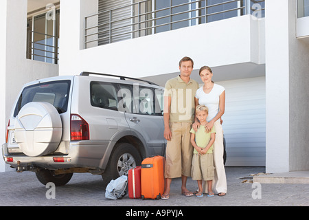 Familie Stand mit dem Auto mit Koffer Stockfoto
