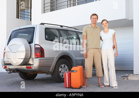 Paar Stand mit dem Auto mit Koffer Stockfoto