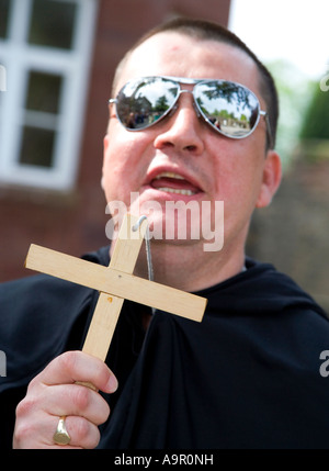 Mann verkleidet sich als Priester mit Kreuz Stockfoto