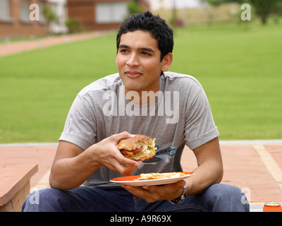 Ein junger Mann mit einem burger Stockfoto