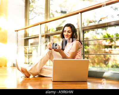 Eine Frau sitzt neben einem Laptop und Tee Stockfoto