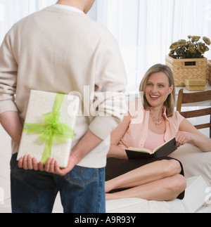 Überraschende Frau mit Geschenk Stockfoto
