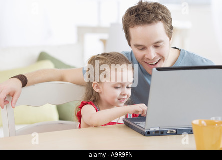 Vater und Tochter auf Laptop tippen Stockfoto