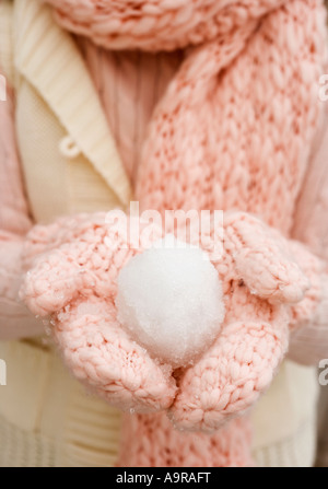 Person mit Schneeball in behandschuhten Händen Stockfoto