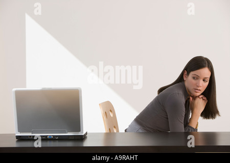 Frau auf der Suche über die Schulter am laptop Stockfoto