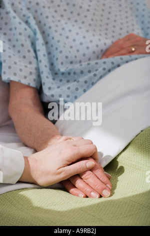 Krankenschwester an senior Frau s Hand im Krankenhaus Stockfoto