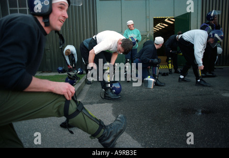 Metropolitan Polizisten setzen auf ihren schützenden Kit in Vorbereitung auf die öffentliche Ordnung Trainingsübungen London UK Stockfoto