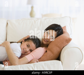 Mutter und Tochter umarmt auf sofa Stockfoto