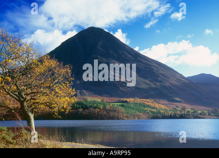 Sonnenlicht durchströmt das Buttermere Tal und die umliegenden Fells macht das herbstliche Farbenspiel Crummock Wasser Leuchten Stockfoto