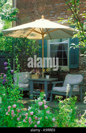 Kleine private Terrasse in einem gemütlichen Garten mit bequemen Möbeln unter einem Sonnenschirm als Schattenspender, Missouri USA-Stadt Stockfoto