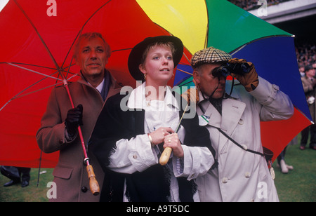 Cheltenham Festival Pferderennen der 1990er Jahre Großbritannien. Die Teilnehmer des Cheltenham Gold Cup-Rennens sind unter einem farbenfrohen Regenschirm geschützt. Gloucestershire England HOMER SYKES Stockfoto