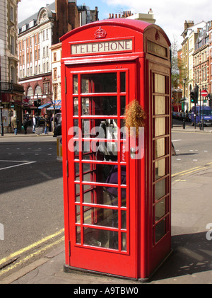 Frau in roten Telefonzelle London England UK Stockfoto