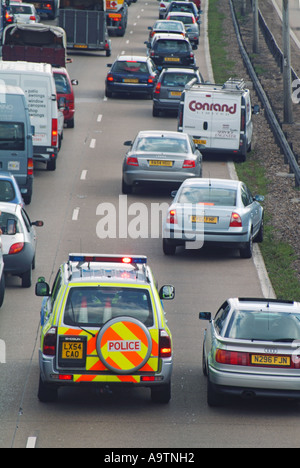 M25 Autobahn Warteschlangen Verkehr Polizeiauto auf Notruf versuchen, Fortschritte, wie Fahrzeuge zu, über bewegen Stockfoto