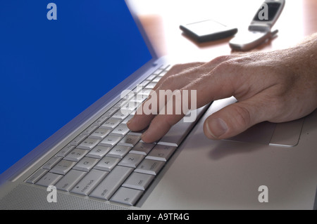 Computer Laptop mit Hand und Handy, PDA, USA Stockfoto