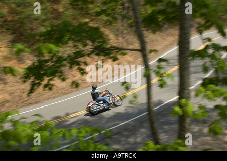 Mann auf einem Motorrad auf einer kurvenreichen Landstraße Stockfoto