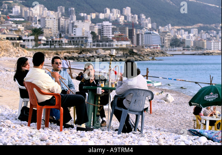 BEIRUT MENSCHEN RAUCHEN WASSERPFEIFEN UM TISCH AM STRAND IN JOUNIE BEREICH 1998 Stockfoto