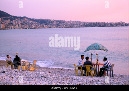 BEIRUT SONNENUNTERGANG MENSCHEN DAS RAUCHEN VON WASSERPFEIFEN UM TISCH AM STRAND IN JOUNIE BEREICH 1998 Stockfoto