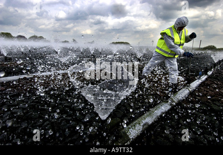 Ein Abwasser-Behandlung-Operator führt wesentliche Reinigung und Wartung Arbeit am Wanlip in Leicester Kläranlagen Stockfoto