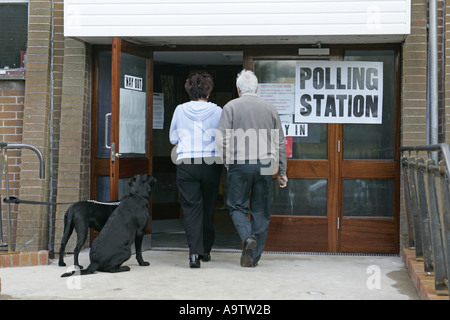 Mann und Frau in einem Wahllokal in Nordirland mit Hunden draußen gefesselt Stockfoto