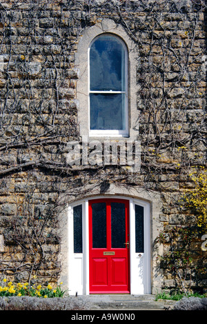 Eine rote Tür und einen Erker oben es in alten Mauerwerk eines Hauses gesetzt. Stockfoto