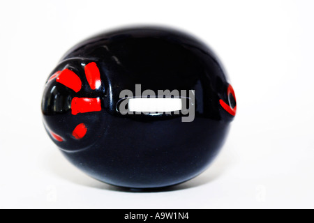 Schwarzes Sparschwein Schwein mit Blick durch die Geld-Schlitz auf der Seite liegend Stockfoto