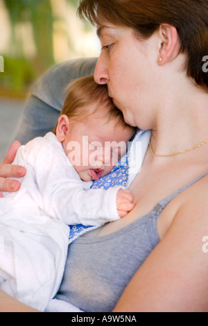 Mutter küssendes schlafendes Baby Stockfoto