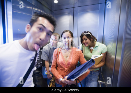 Studenten im Aufzug lustige Grimassen Stockfoto