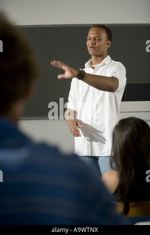 Lehrer stehen in die Klassenzimmer Gestikulieren in Richtung Klasse Stockfoto