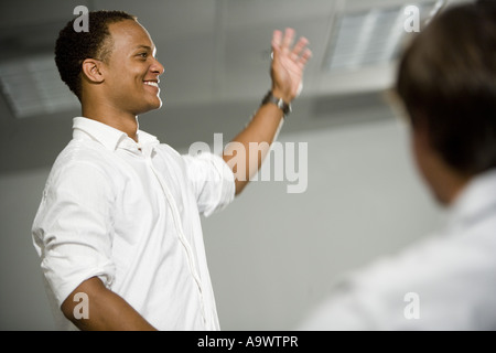 Lehrer stehen in die Klassenzimmer Gestikulieren in Richtung Klasse Stockfoto