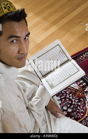 Porträt eines muslimischen Mannes lesen Koran auf einen Gebetsteppich Stockfoto