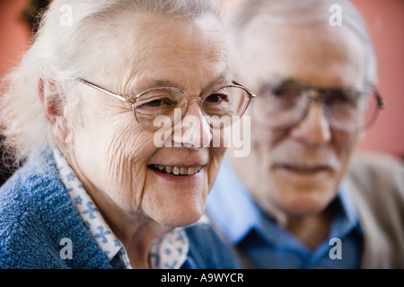 Nahaufnahme von senior Frau lächelnd mit senior Mann im Hintergrund Stockfoto