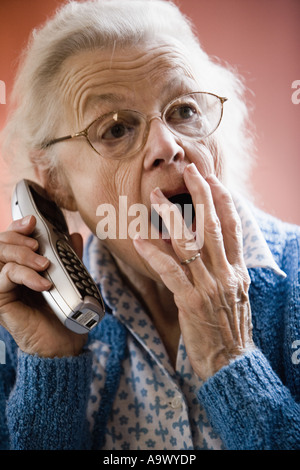 Überrascht und unglücklich senior Frau schnurlos telefonieren Stockfoto