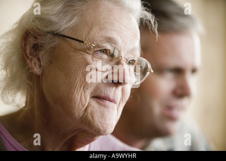 Nahaufnahme der lächelnde ältere Frau mit Mann im Hintergrund Stockfoto