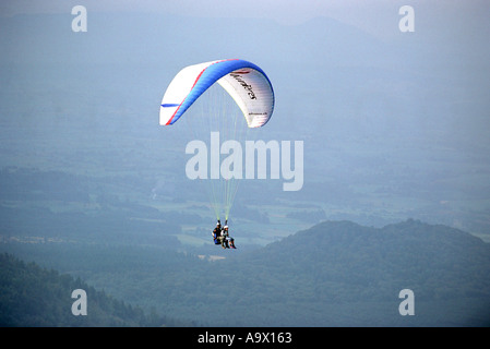 Tandem Gleitschirm über den Wald am Puy de Dome in der Region Auvergne, Frankreich Stockfoto