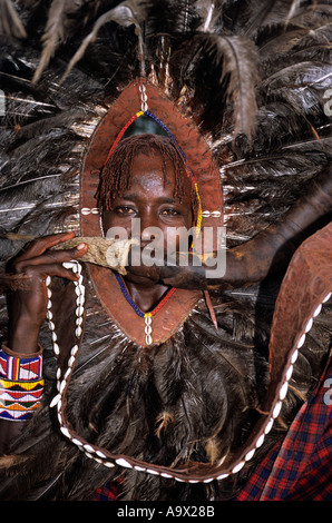 Lolgorian, Kenia. Siria Maasai Manyatta; Moran "Löwenkopf" mit Horn Musikinstrument. Stockfoto